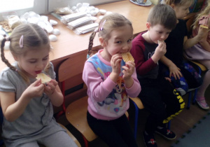 Dzieci zajadające wafelki z miodem .